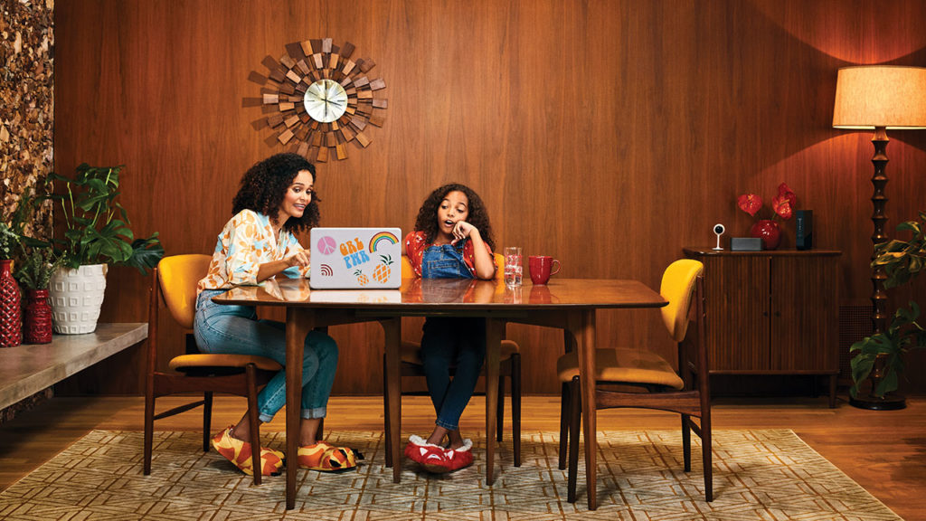 Mother and daughter sitting at a table looking at a computer