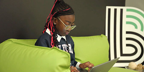 Girl sitting on a couch working on a laptop